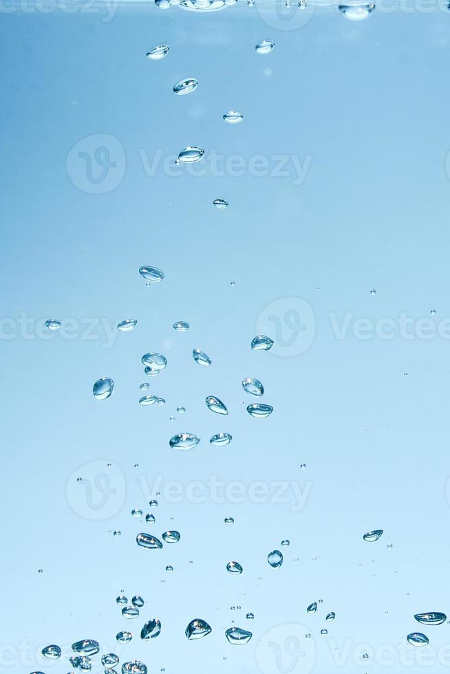 abstracte achtergrondafbeelding van bellen in water. schoon water met waterdruppels en golven. zoet water een glas met bubbels blauwe achtergrond. foto