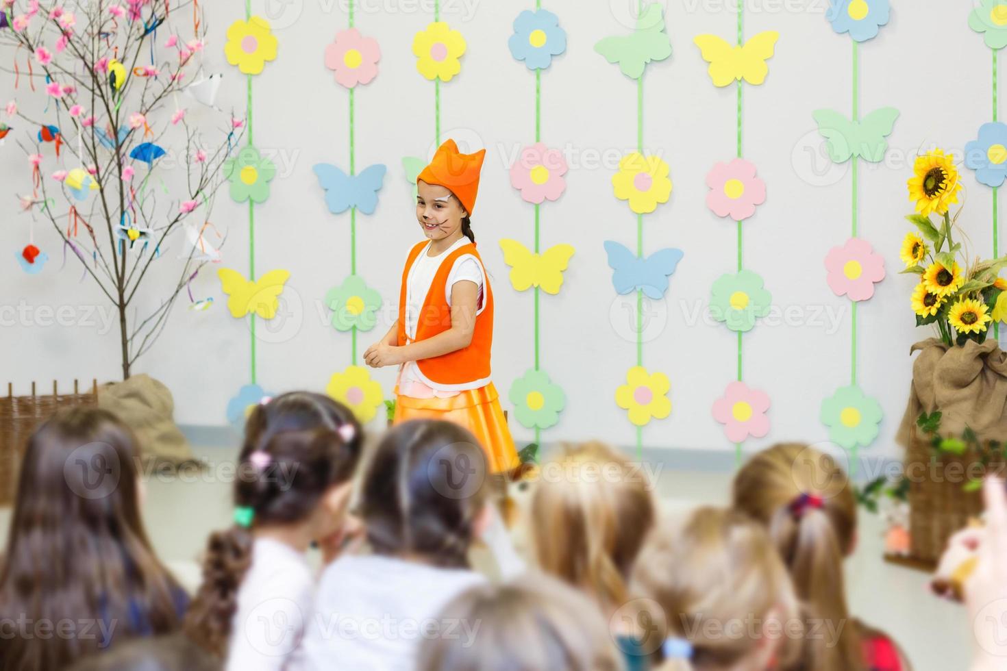 jong actrice in een vos kostuum sprekend in voorkant van kinderen foto