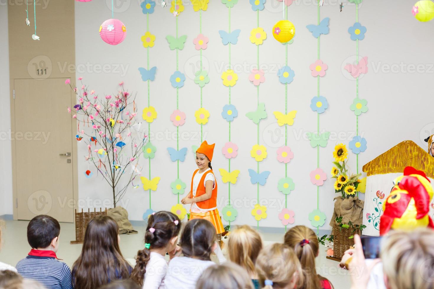 jong actrice in een vos kostuum sprekend in voorkant van kinderen foto