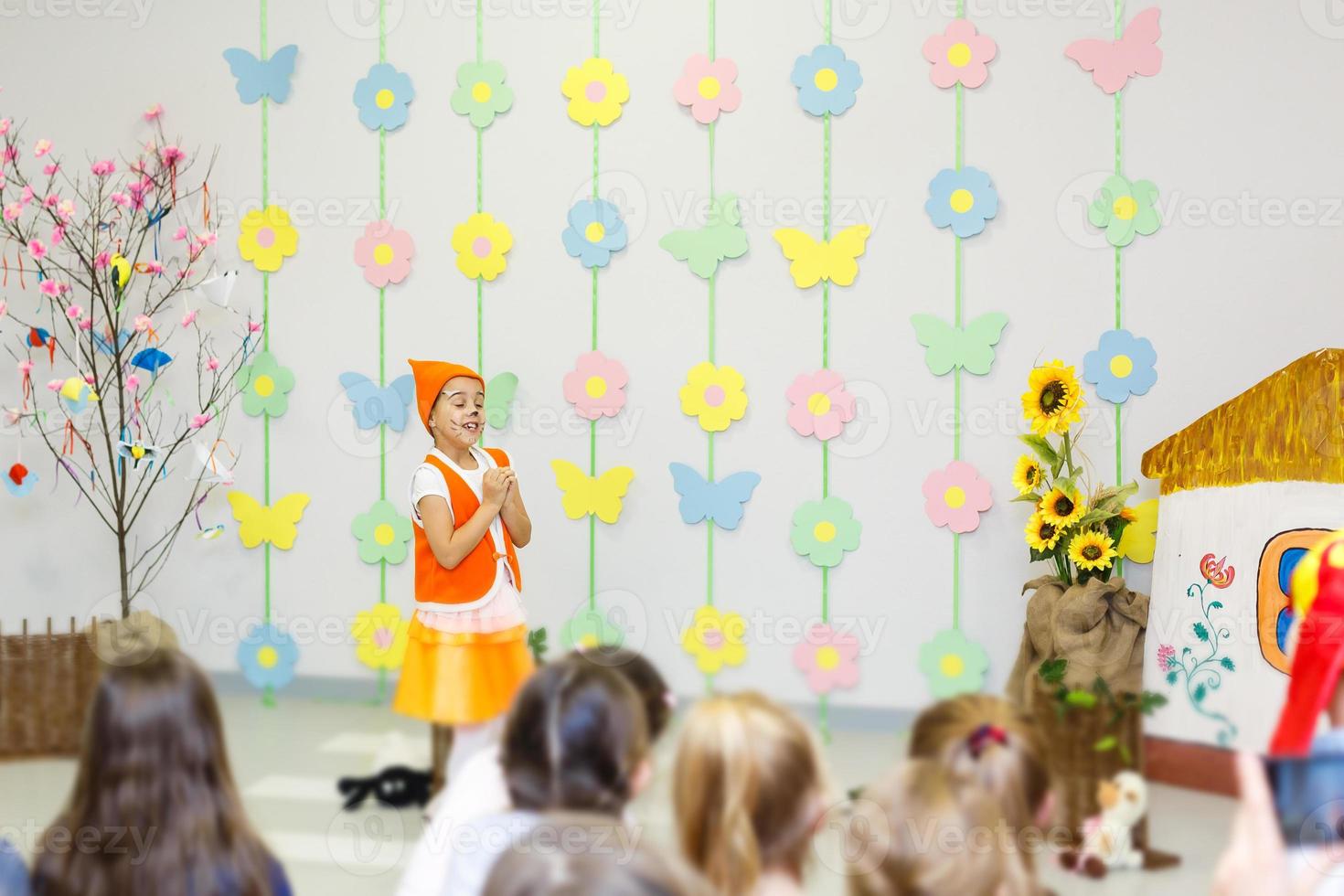 jong actrice in een vos kostuum sprekend in voorkant van kinderen foto