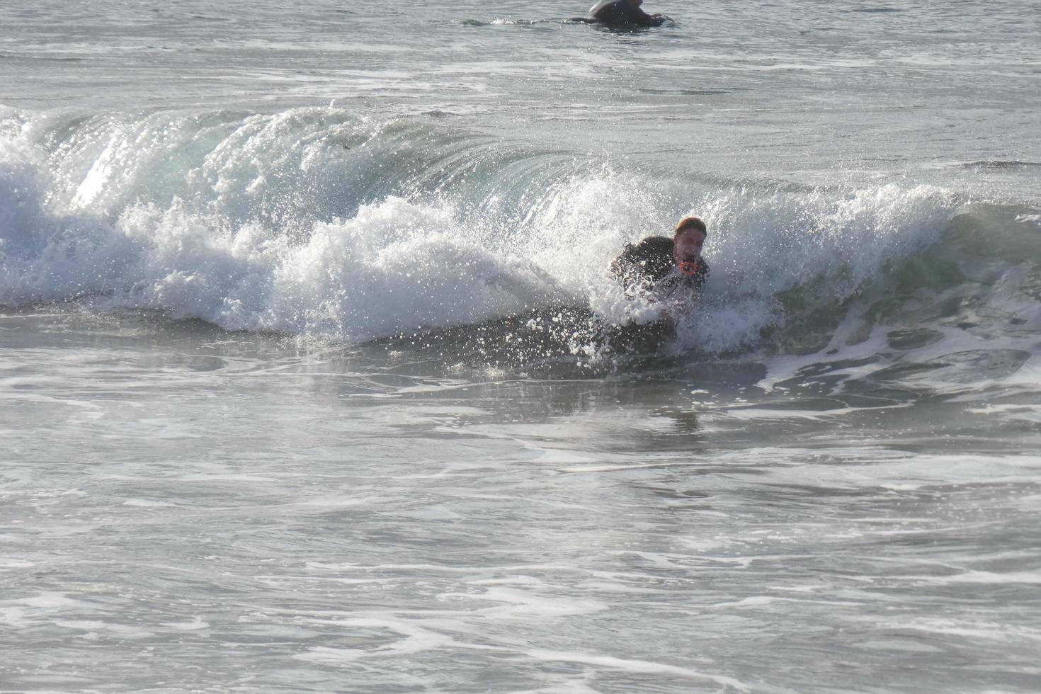 surfers rijden klein oceaan golven foto