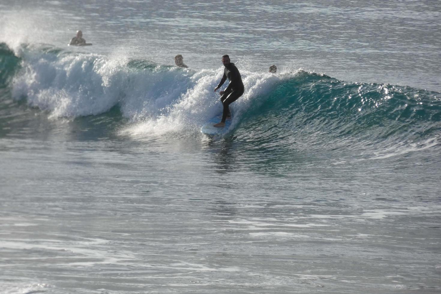 surfers rijden klein oceaan golven foto