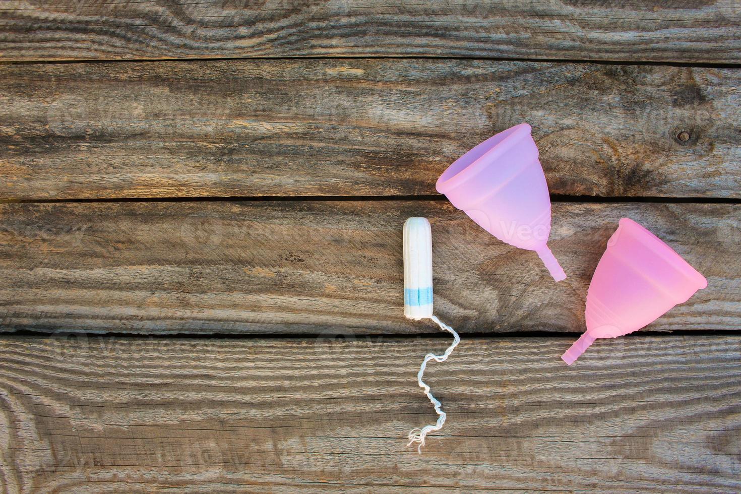 menstruatie- kop en tampons Aan oud houten achtergrond. top visie. foto