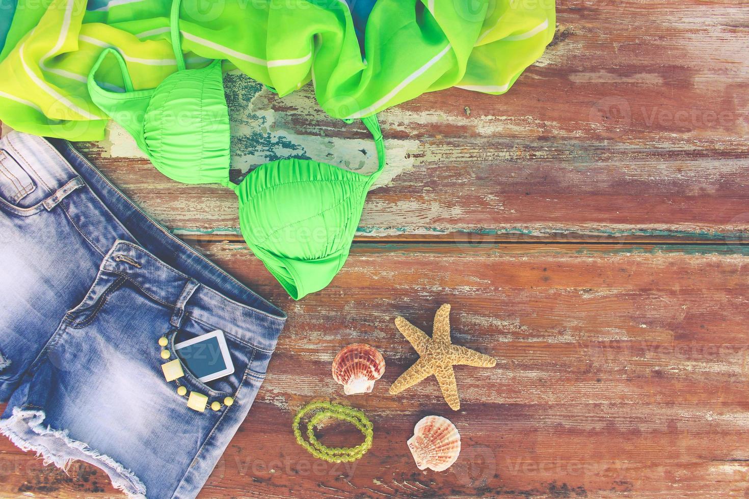 zomer vrouwen kleding en accessoires denim korte broek, het baden pak, pareo, schelpen, mobiel telefoon. top visie. afgezwakt afbeelding. foto