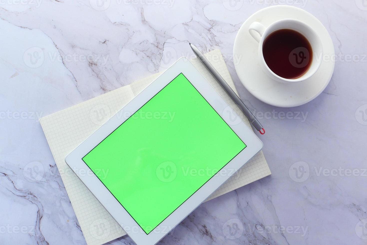 vlakke samenstelling van digitale tablet en koffiekopje op marmeren achtergrond foto