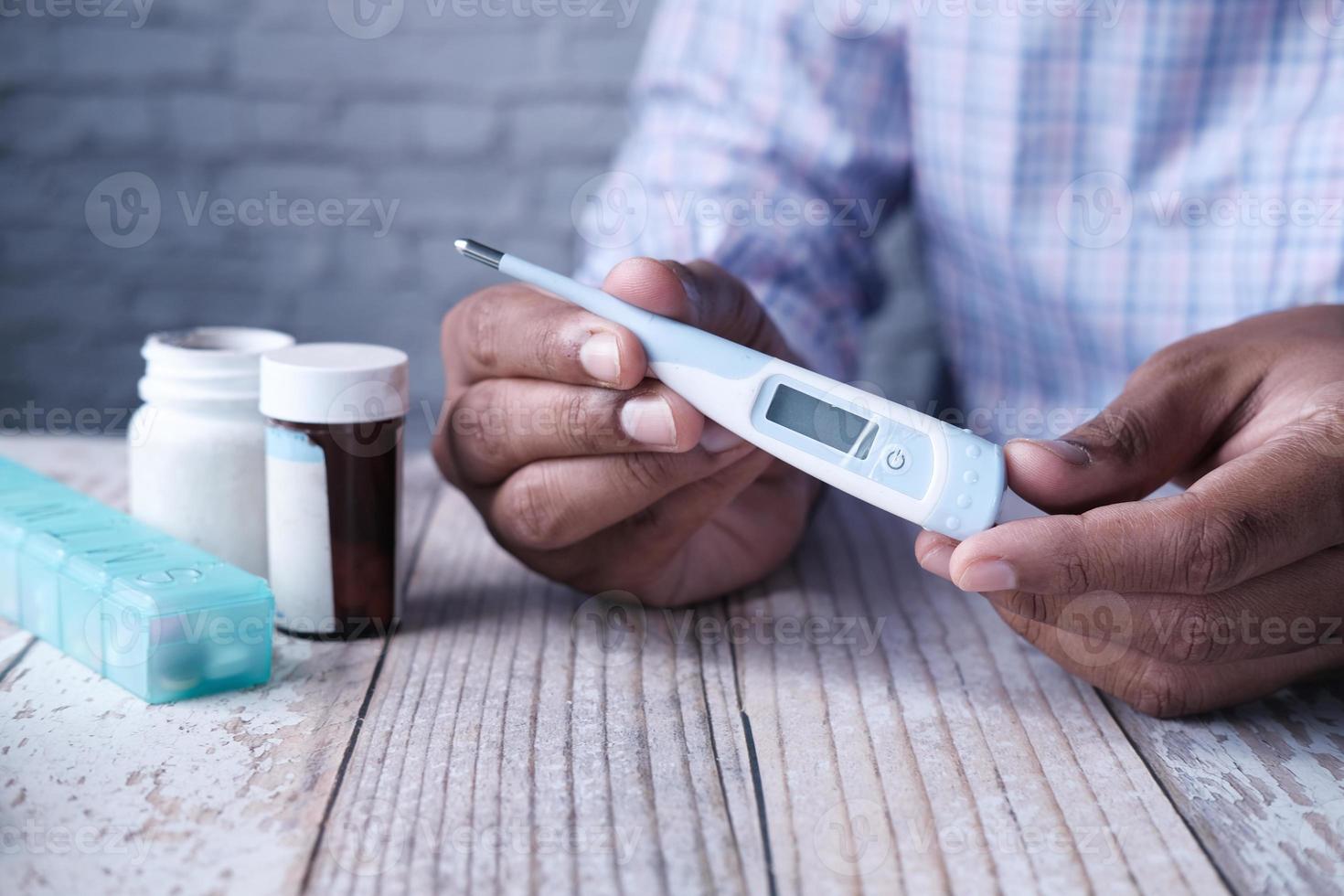 man met digitale thermometer in de hand foto