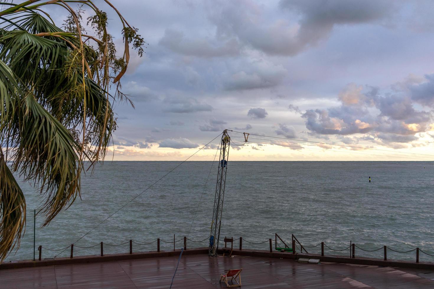 lege promenade met uitzicht op de zee naast een palmboom en een watermassa in Sotsji, Rusland foto