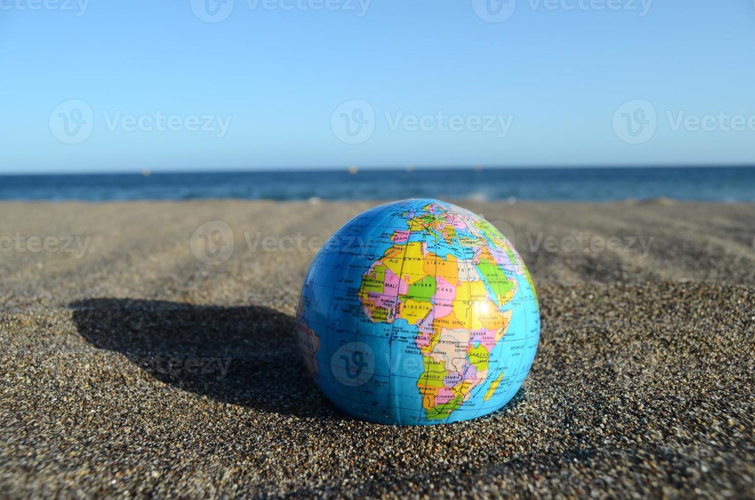wereldbol in de zand foto