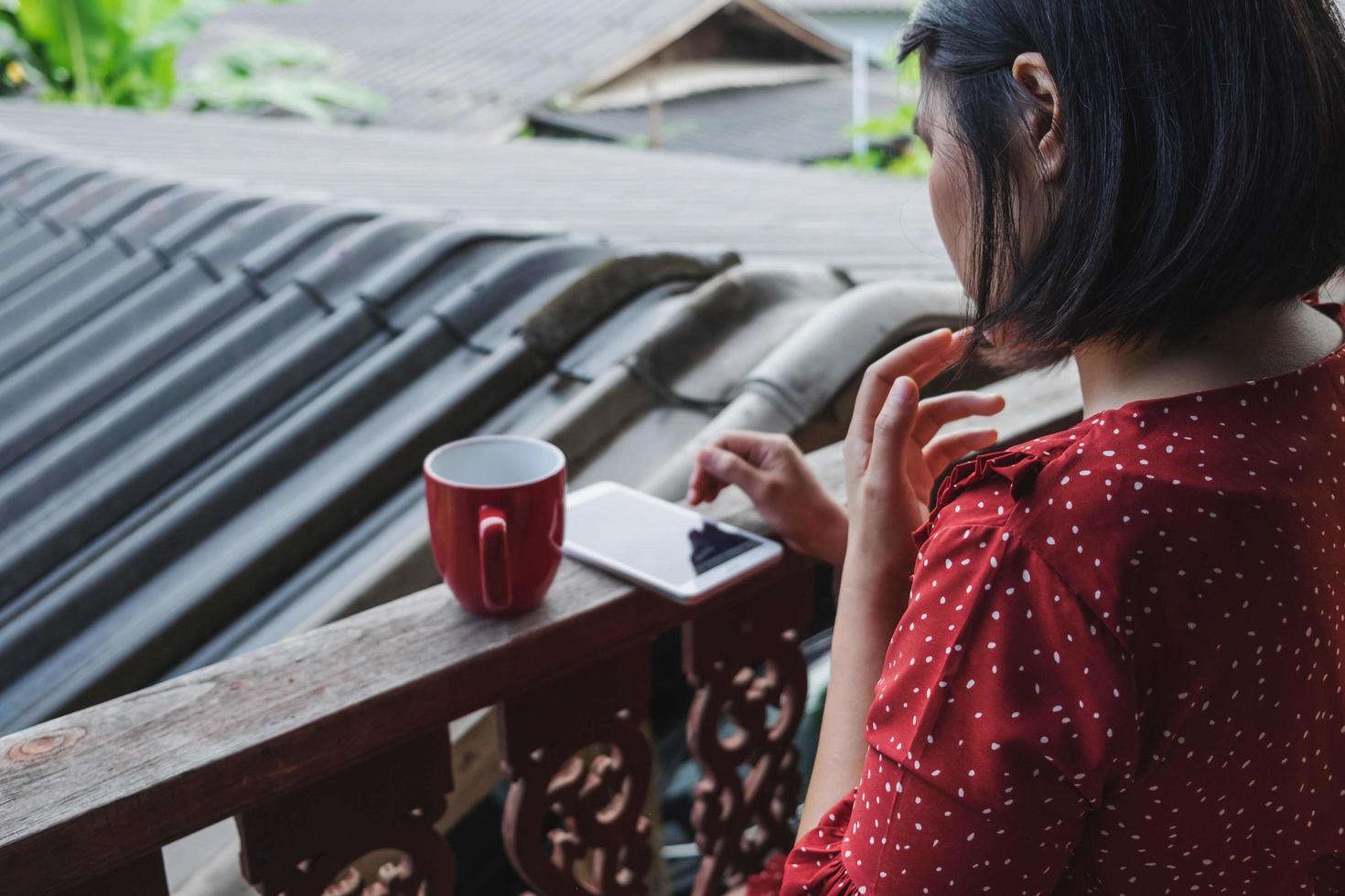 vrouw op haar telefoon met een kopje koffie foto