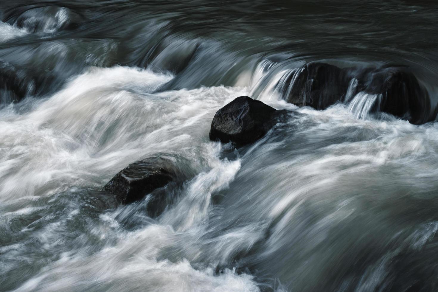 donkere stenen in de rivier foto