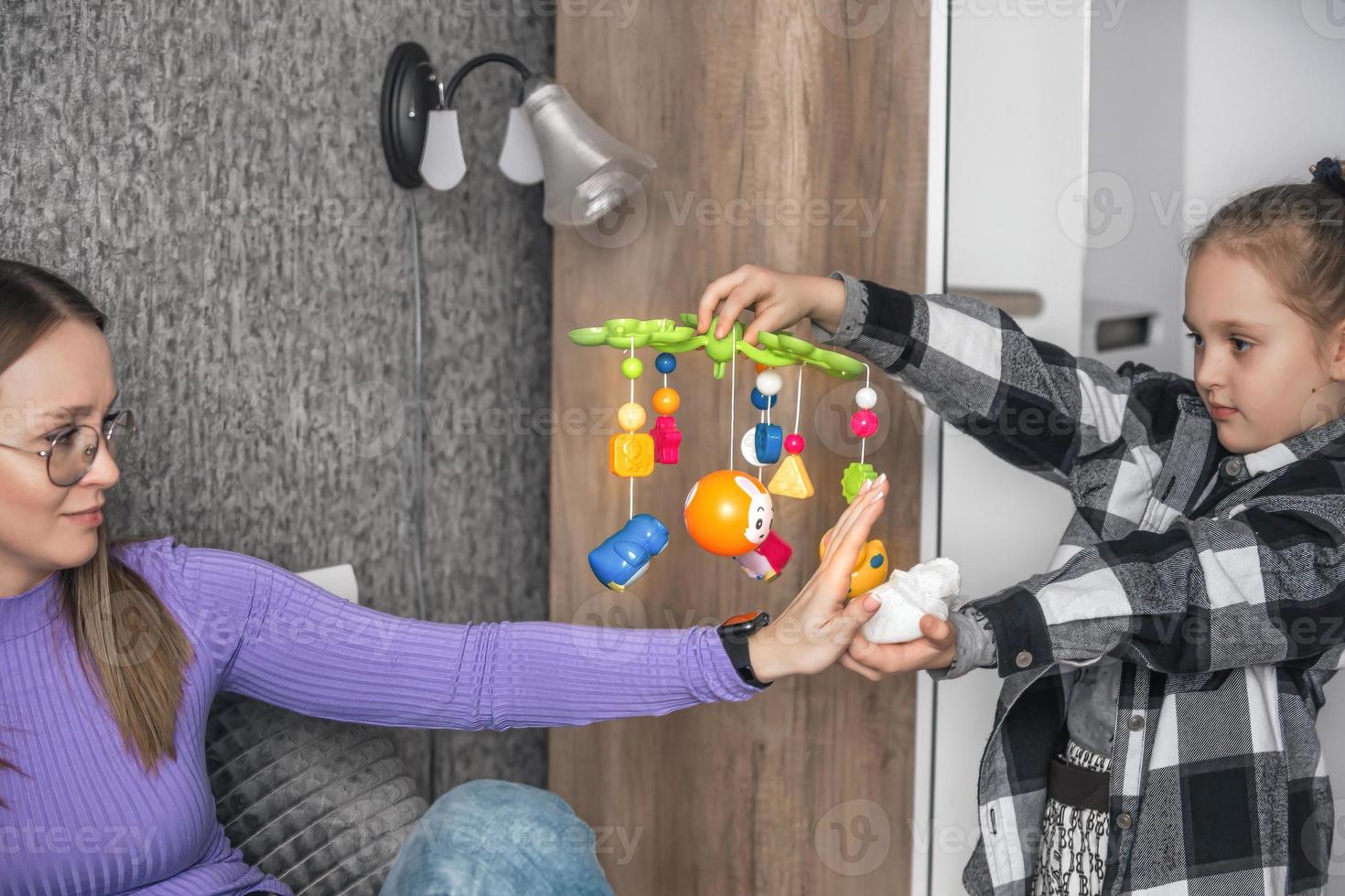 de meisje vraagt haar moeder naar geven geboorte naar haar weinig broer of zus, de moeder is pratend Aan de telefoon en weigert haar dochter. vrouwen onwil naar hebben kinderen, een kind in de familie foto