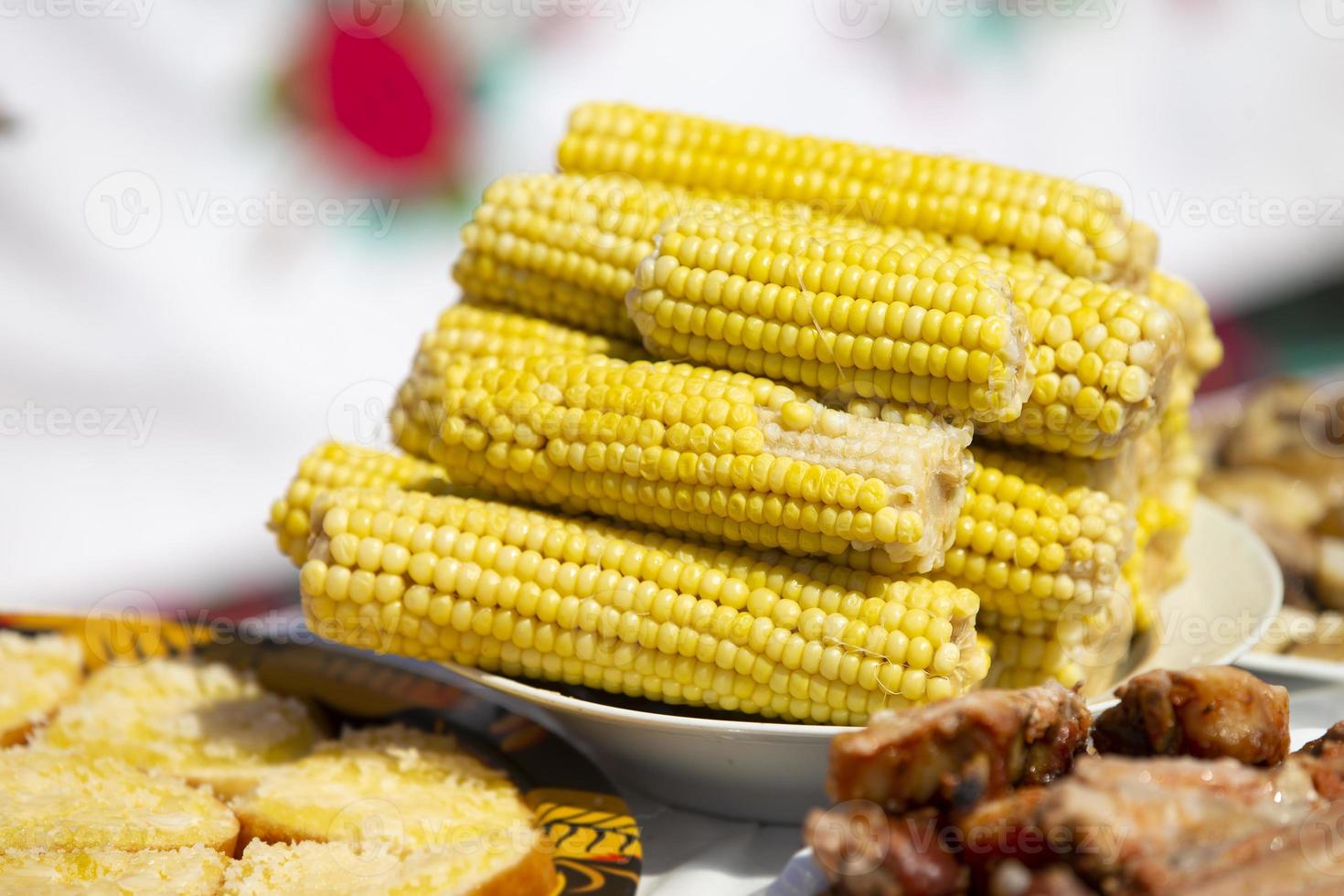 gekookt oren van maïs in een bord Aan de tafel. foto