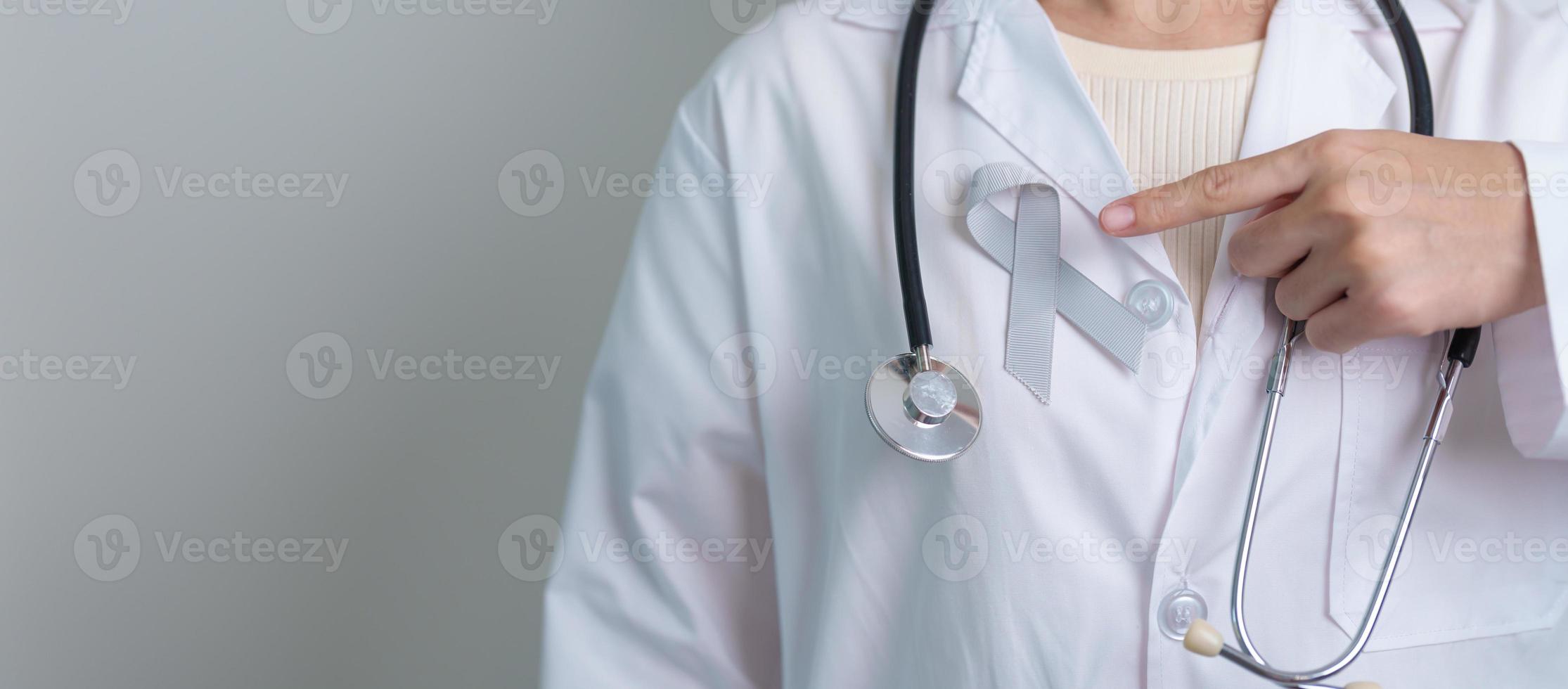 hersenen kanker bewustzijn mei maand, dokter met grijs kleur lint voor ondersteunen leven mensen. gezondheidszorg en wereld kanker dag concept foto