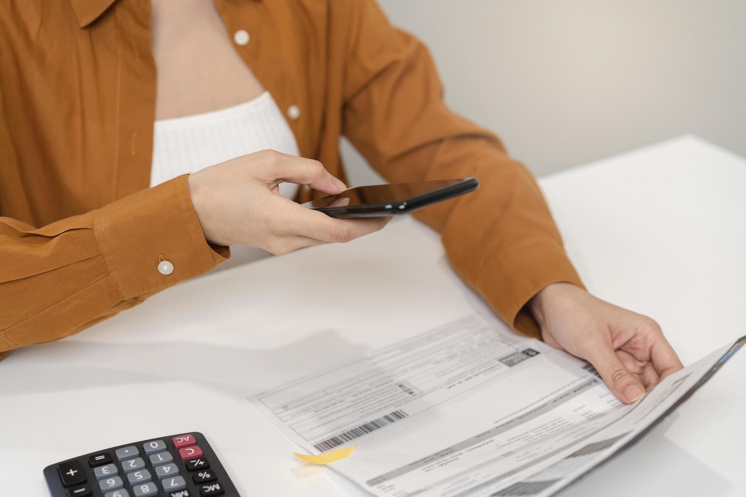 gemak online internet bankieren, Aziatisch jong vrouw hand- in betaling rekening, uitgeven door scannen qr code, gebruik telefoon, mobiel naar overdracht of betalen geld van credit kaart zonder contant geld. technologie van financieel. foto