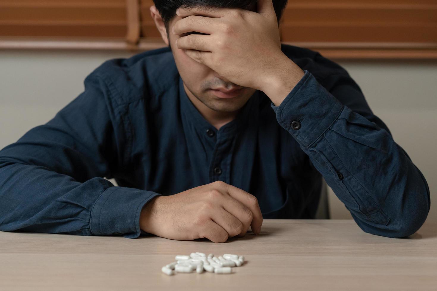 gestrest, verdrietig Aziatisch jong Mens, mannetje misbruik overdosis pillen en verslaafde, nemen geneesmiddel. ziek pijn van Gezondheid behandeling, ongelukkig mensen. zelfmoord depressief of wanhoop. foto