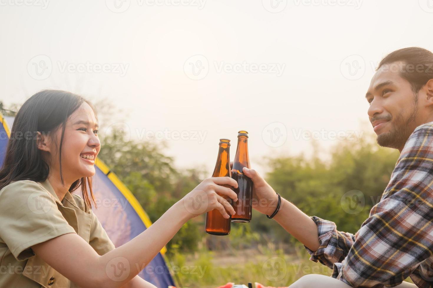 genieten Aziatisch jong vrouw, meisje en Mens juichen met bier fles, zittend Aan stoel . avontuur stel, mensen camping in Woud. eco werkzaamheid, levensstijl natuur Aan vakantie concept. foto