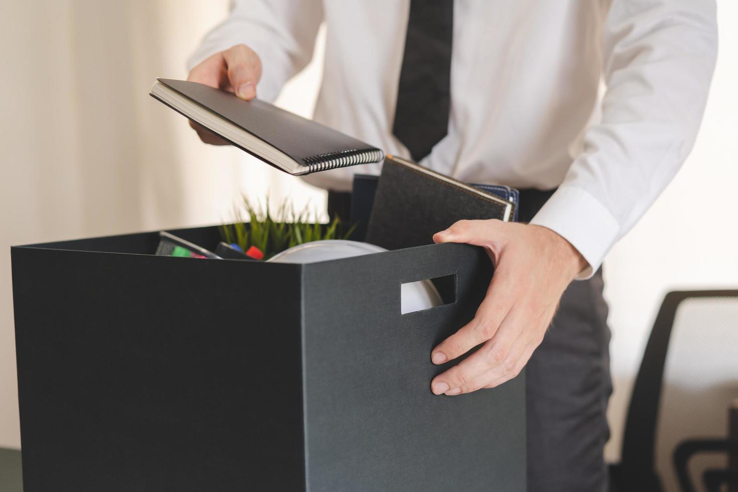 werkloos, heel functie. ten einde raad Kaukasisch jong zakenman aftreden van bedrijf, hand- Holding spullen in de karton, inpakken bezittingen, ontslag of veranderen werk. ontslag, tewerkstelling concept foto