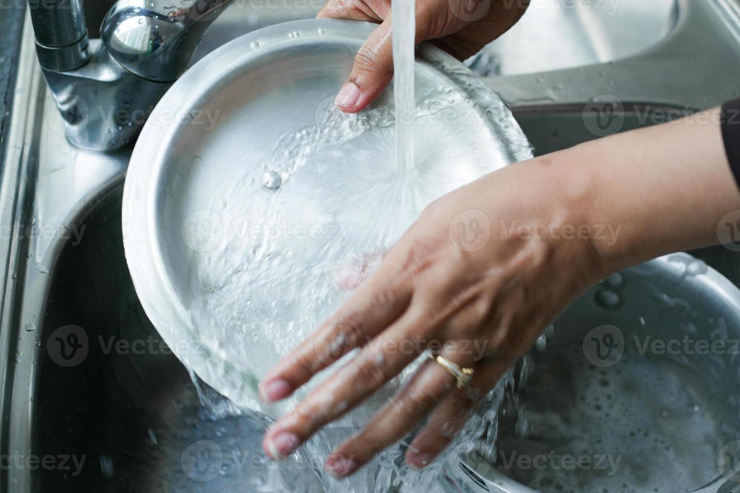vrouw huisvrouw het wassen een Koken pan foto