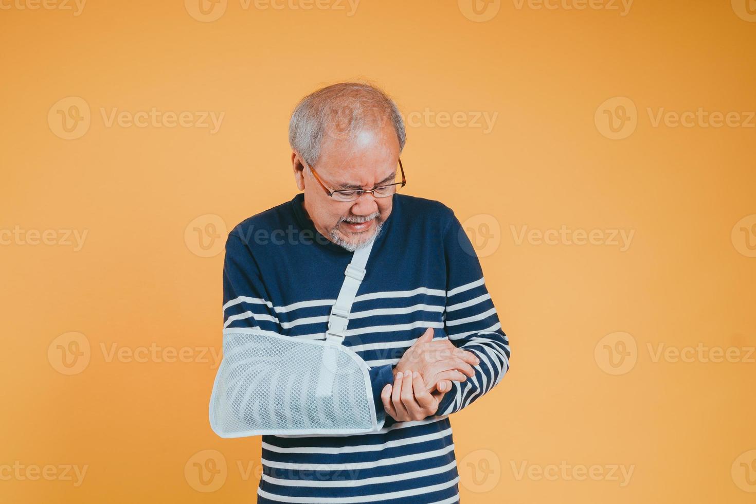 arm gebroken. senior mannetje draagdoek ondersteuning hand- zelfverzekerd glimlach gebroken na ongeluk slijtage arm spalk voor behandeling tonen mooi zo teken. Gezondheid verzekering Aan mobiel concept. foto