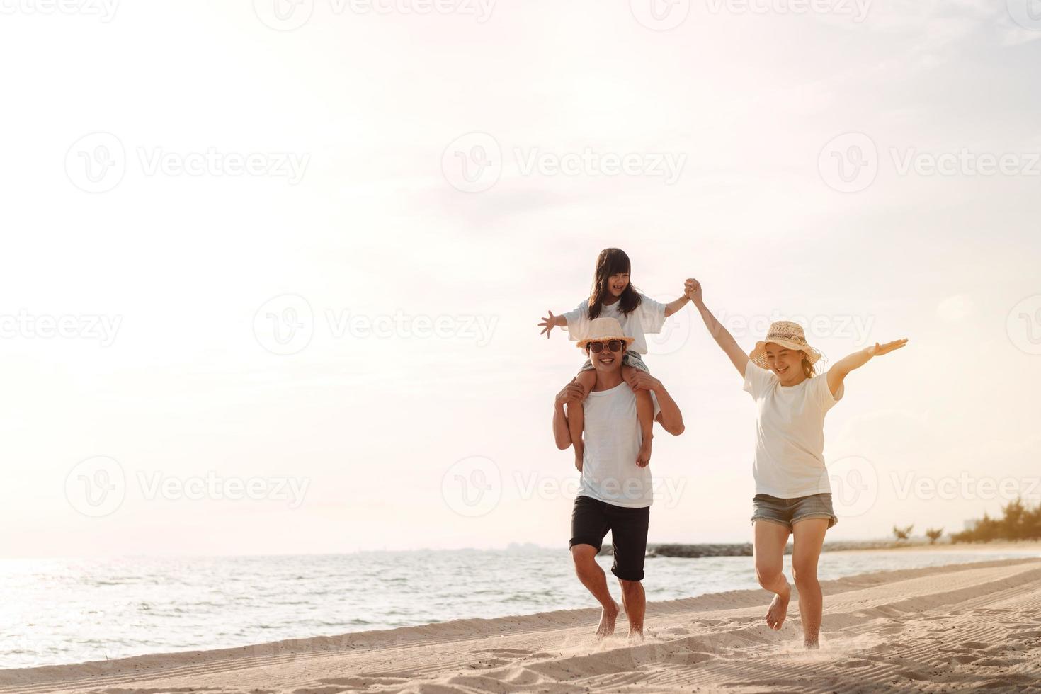 gelukkig Aziatisch familie genieten de zee strand Bij bestaande vader, moeder en dochter hebben pret spelen strand in zomer vakantie Aan de oceaan strand. gelukkig familie met vakanties tijd levensstijl concept. foto