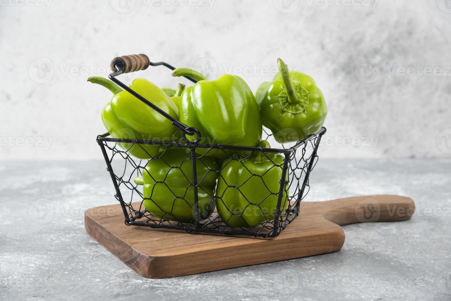 verse groene paprika in een metalen mandje op een stenen achtergrond foto