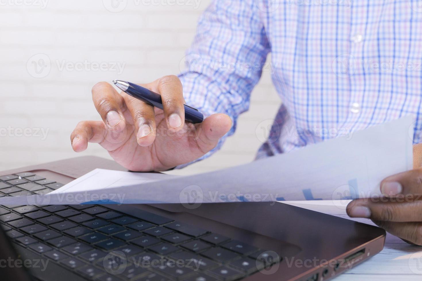 man aan het werk met pen en papier foto