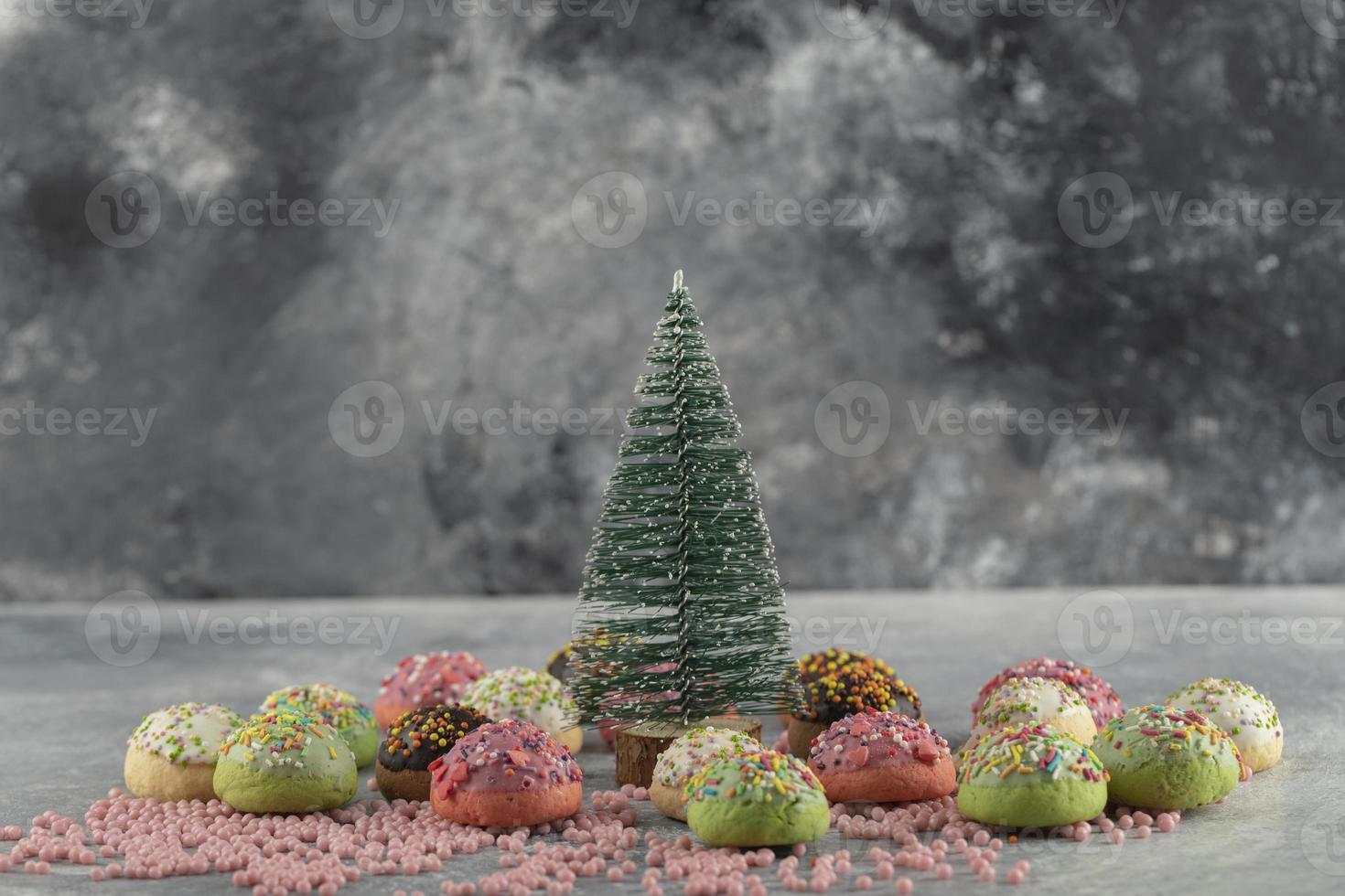 kleurrijke zoete kleine donuts met hagelslag en een kerst versiering foto