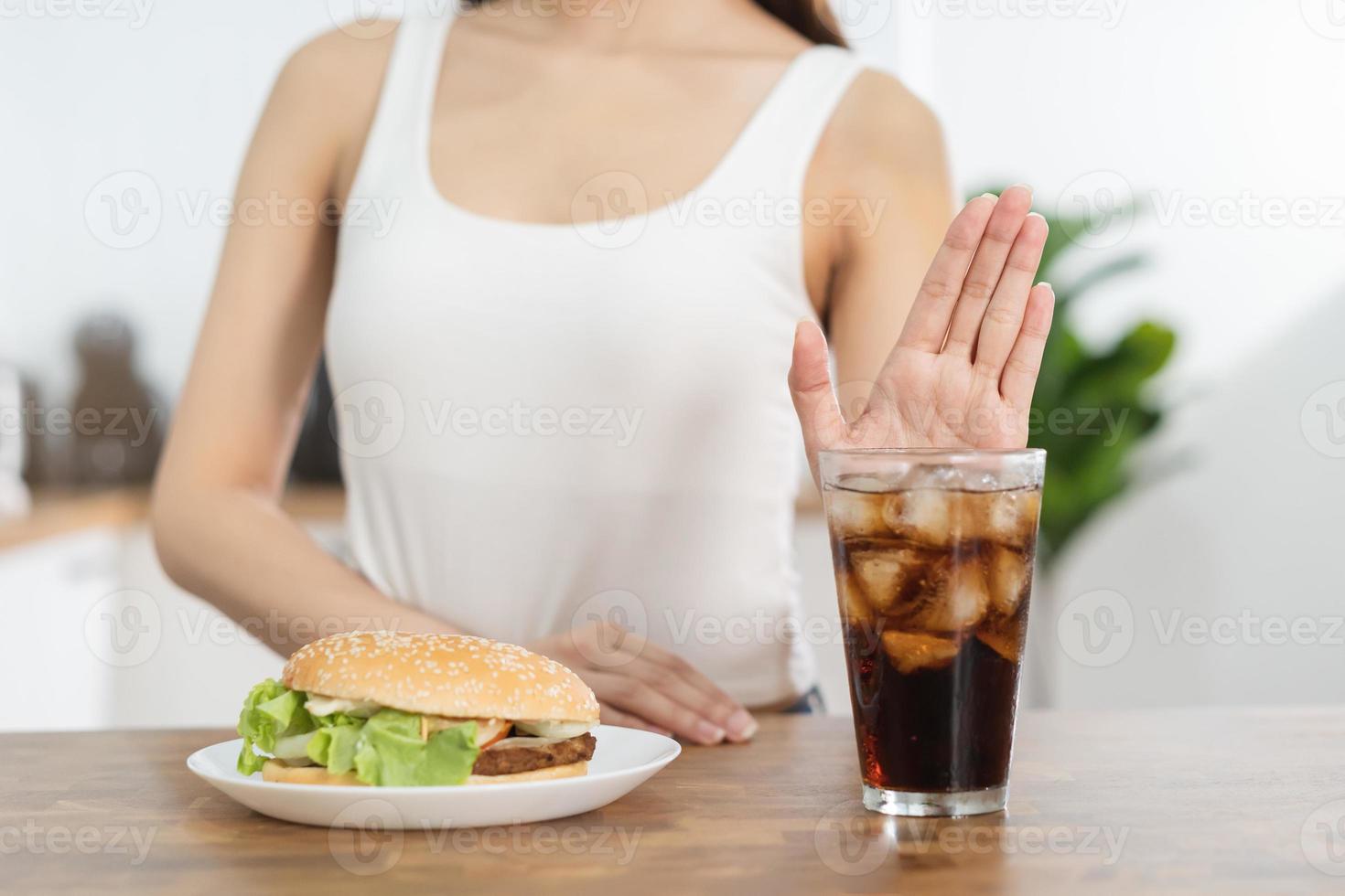 eetpatroon, dieet hand- van Aziatisch jong vrouw ontkennen, vermijden Hamburger, rommel of snel voedsel en sprankelend water, zacht drankje, eten voedsel voor mooi zo gezond, Gezondheid wanneer hongerig. verleiding van gewicht verlies mensen. foto