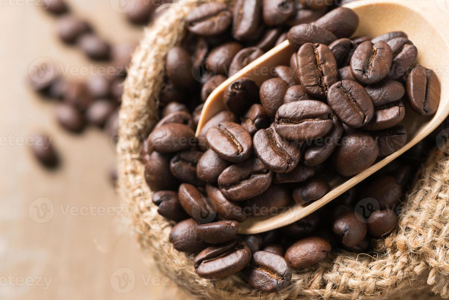 Gesloten omhoog van geroosterd koffie bonen in hout lepel foto