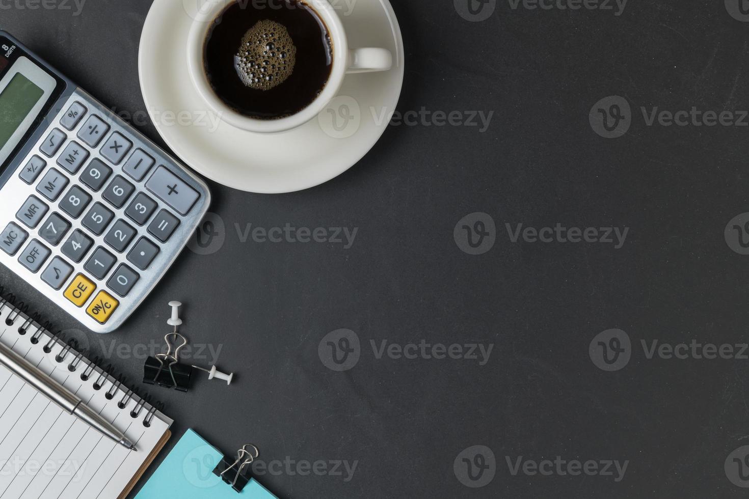 kantoor zwart steen bureau tafel met rekenmachine, zwart koffie en pen foto