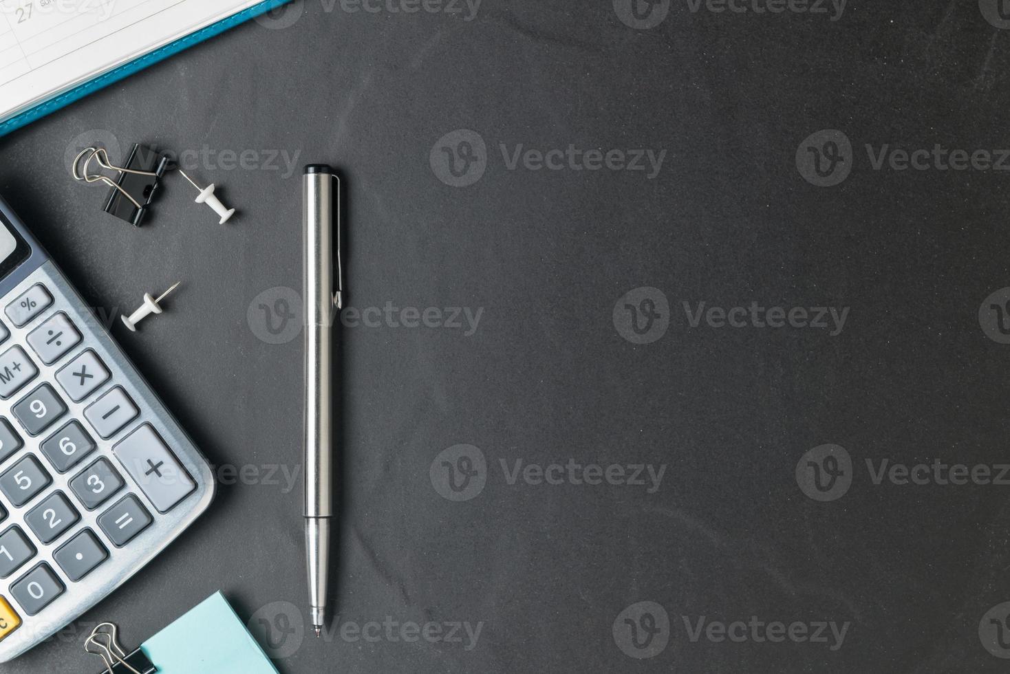 kantoor zwart steen bureau tafel met rekenmachine en pen foto