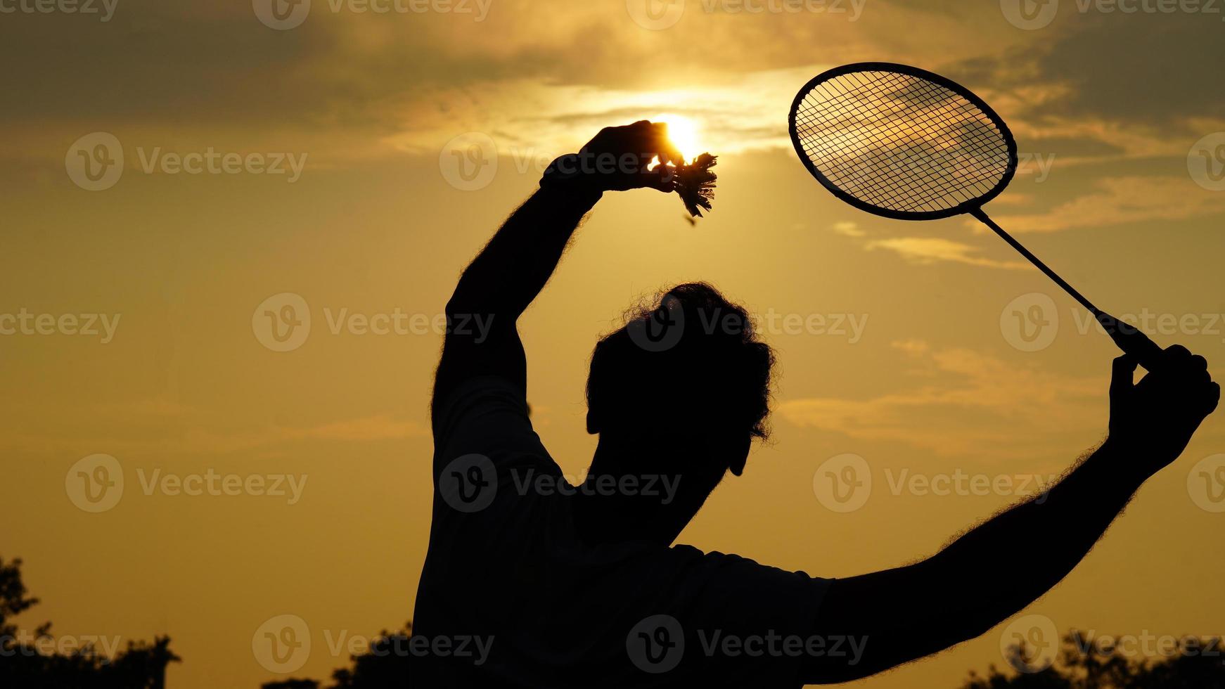silhouetten Mens spelen badminton met nemen een shuttle in hand- foto
