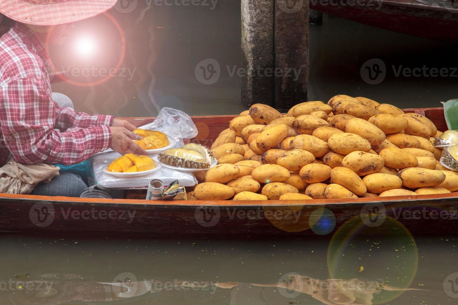 boten verkoop fruit - rijp mango - in damnoen saduak drijvend markt is een populair toerist bestemming dat Europeanen en Chinese Leuk vinden naar reizen met de traditioneel manier van leven van de dorpelingen. foto