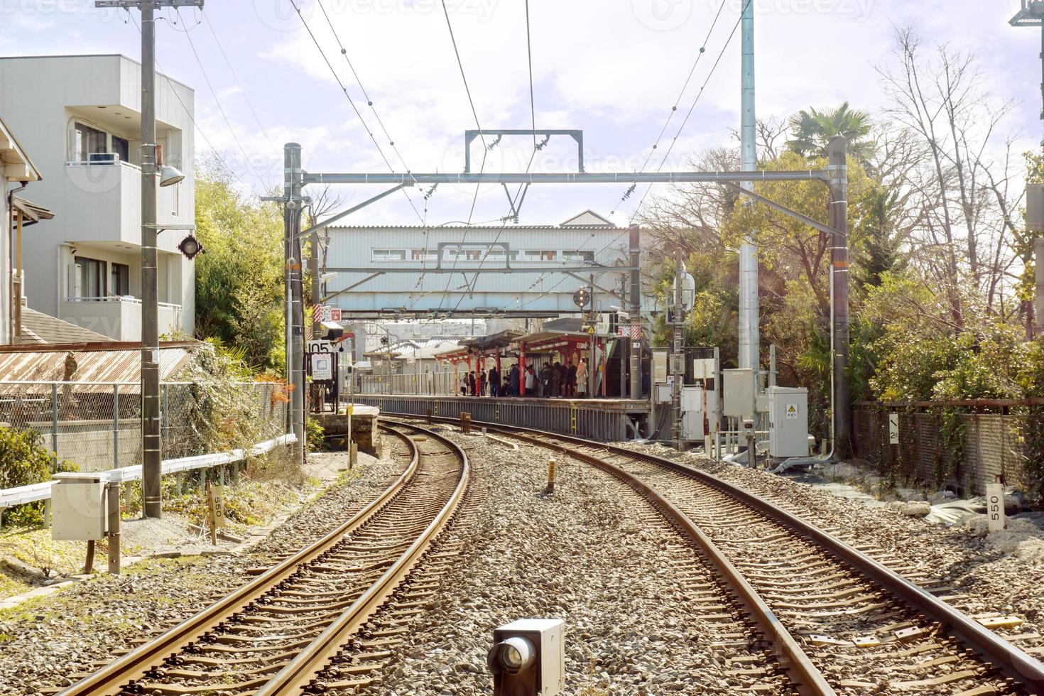 metaal en steengoed spoorweg sporen en stadsgezicht Aan bocht blusachtig en wazig achtergrond van menigte mensen aan het wachten trein Bij trein platform. foto