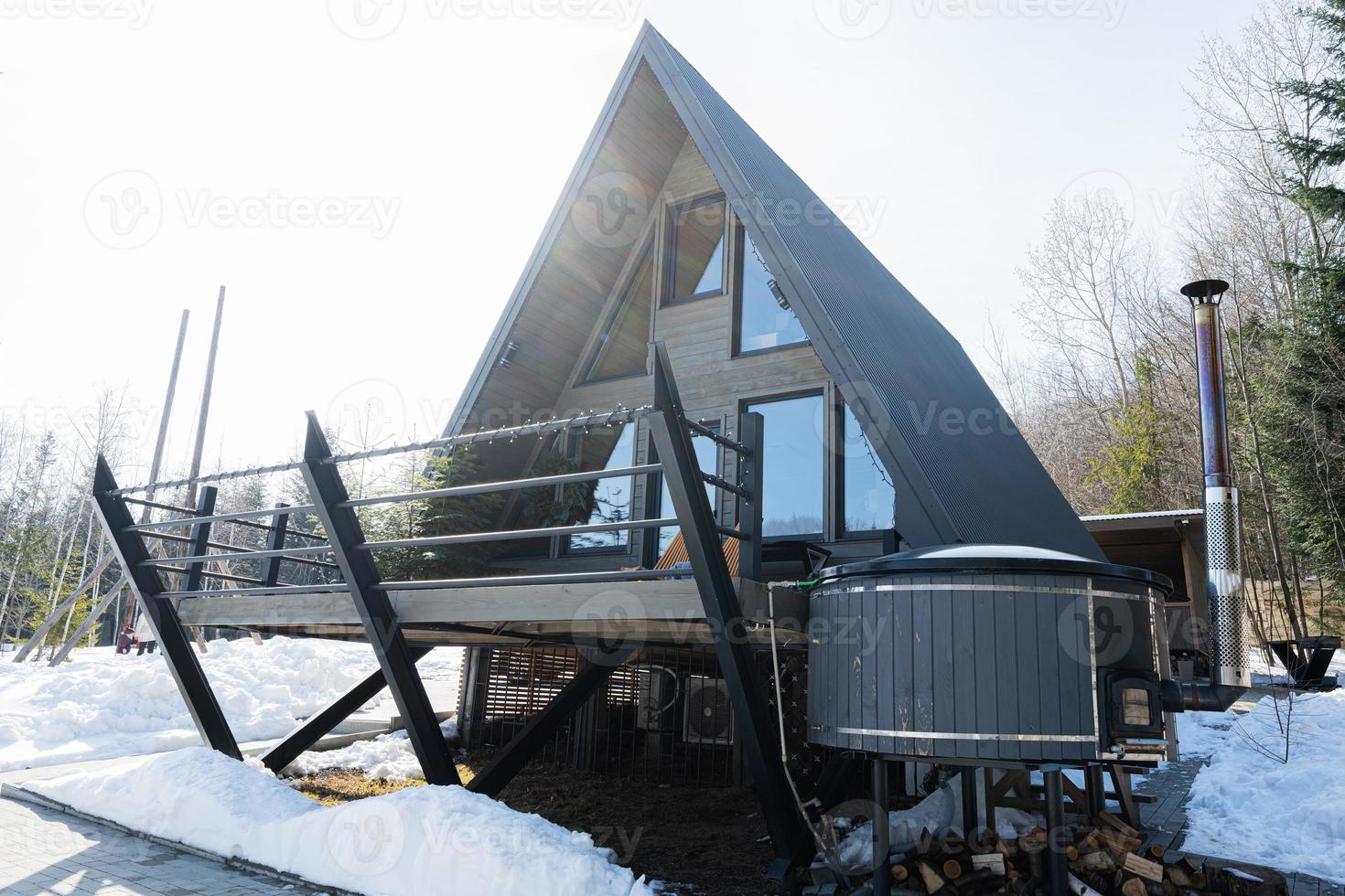houten driehoek land klein cabine huis met heet kuip spa in bergen. ziel weekenden. foto