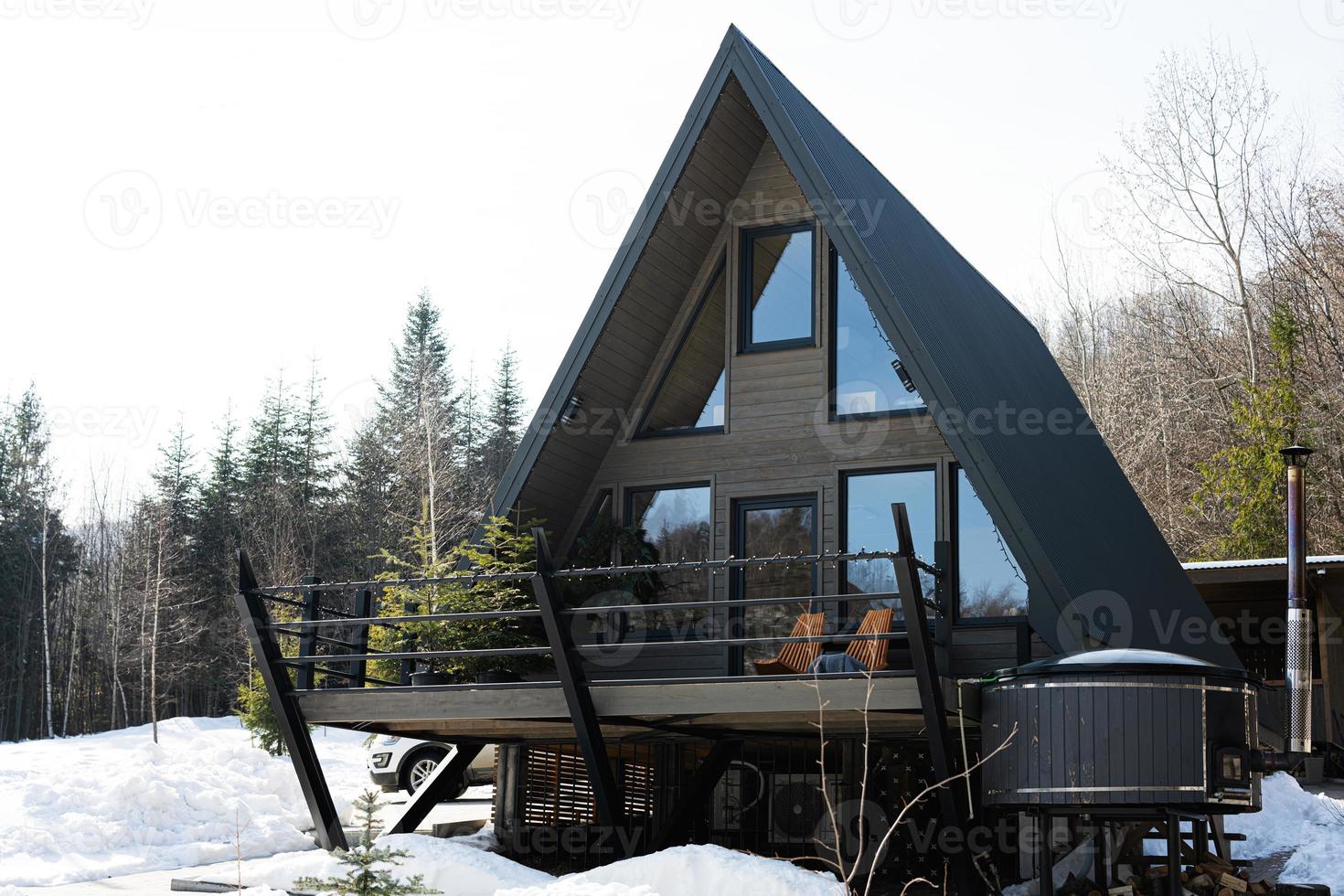 houten driehoek land klein cabine huis met heet kuip spa en suv auto in bergen. ziel weekenden. foto