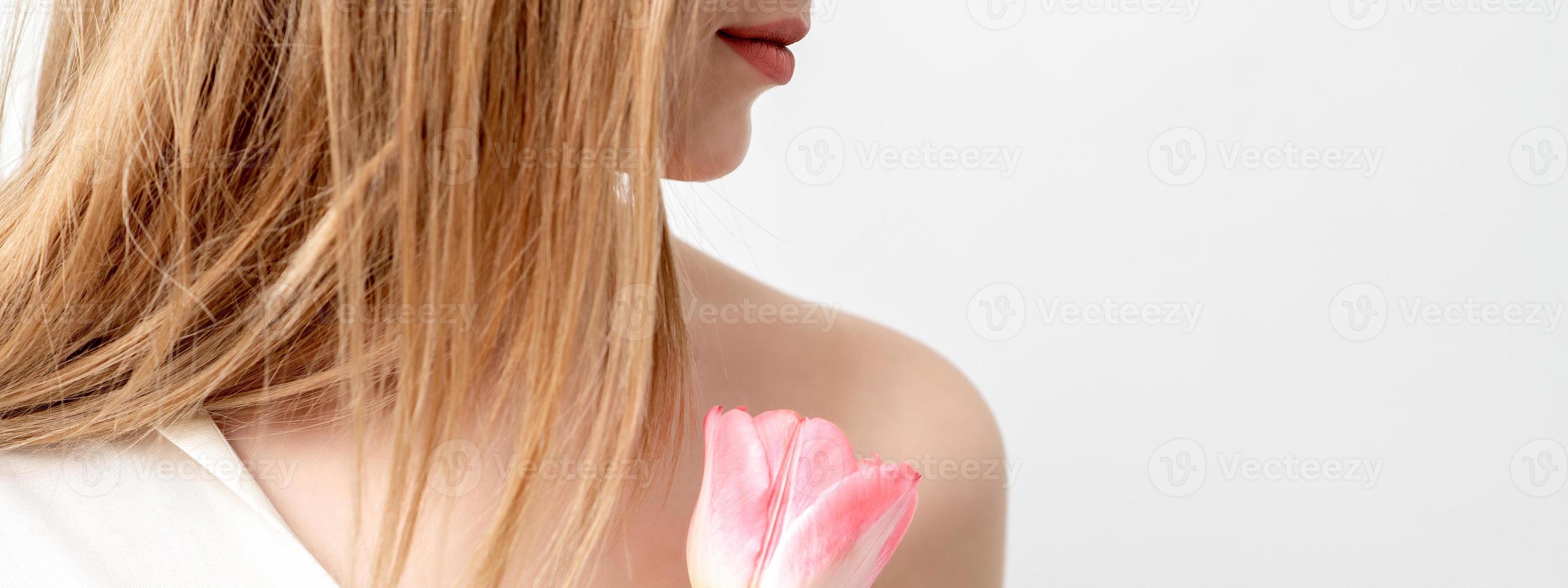 vrouw met een roze tulp foto