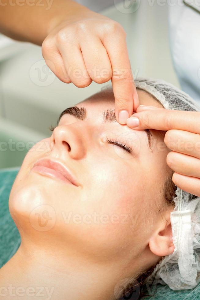 schoonheidsspecialist maken massage Aan wenkbrauw foto