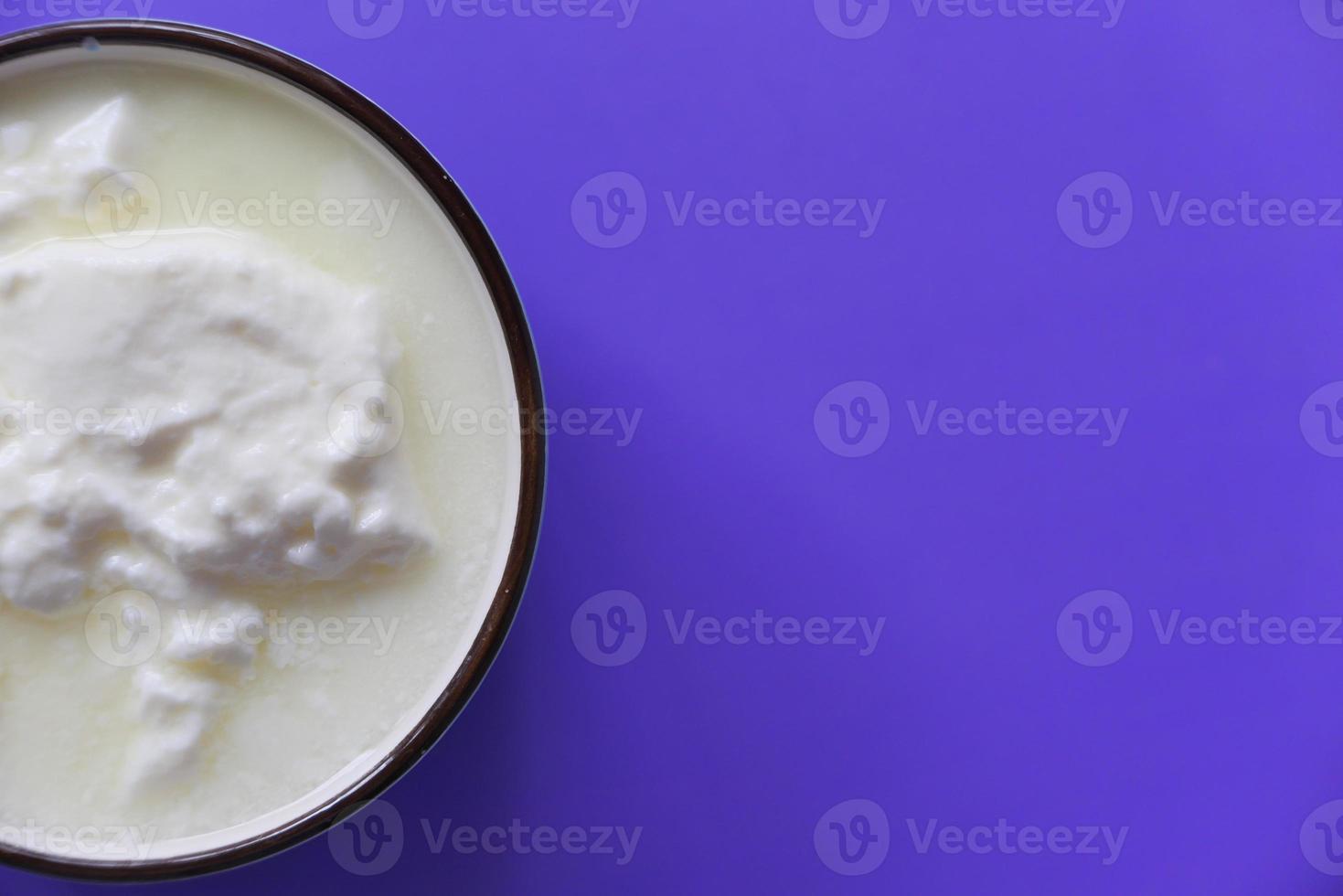 verse yoghurt in een kom op paarse achtergrond foto