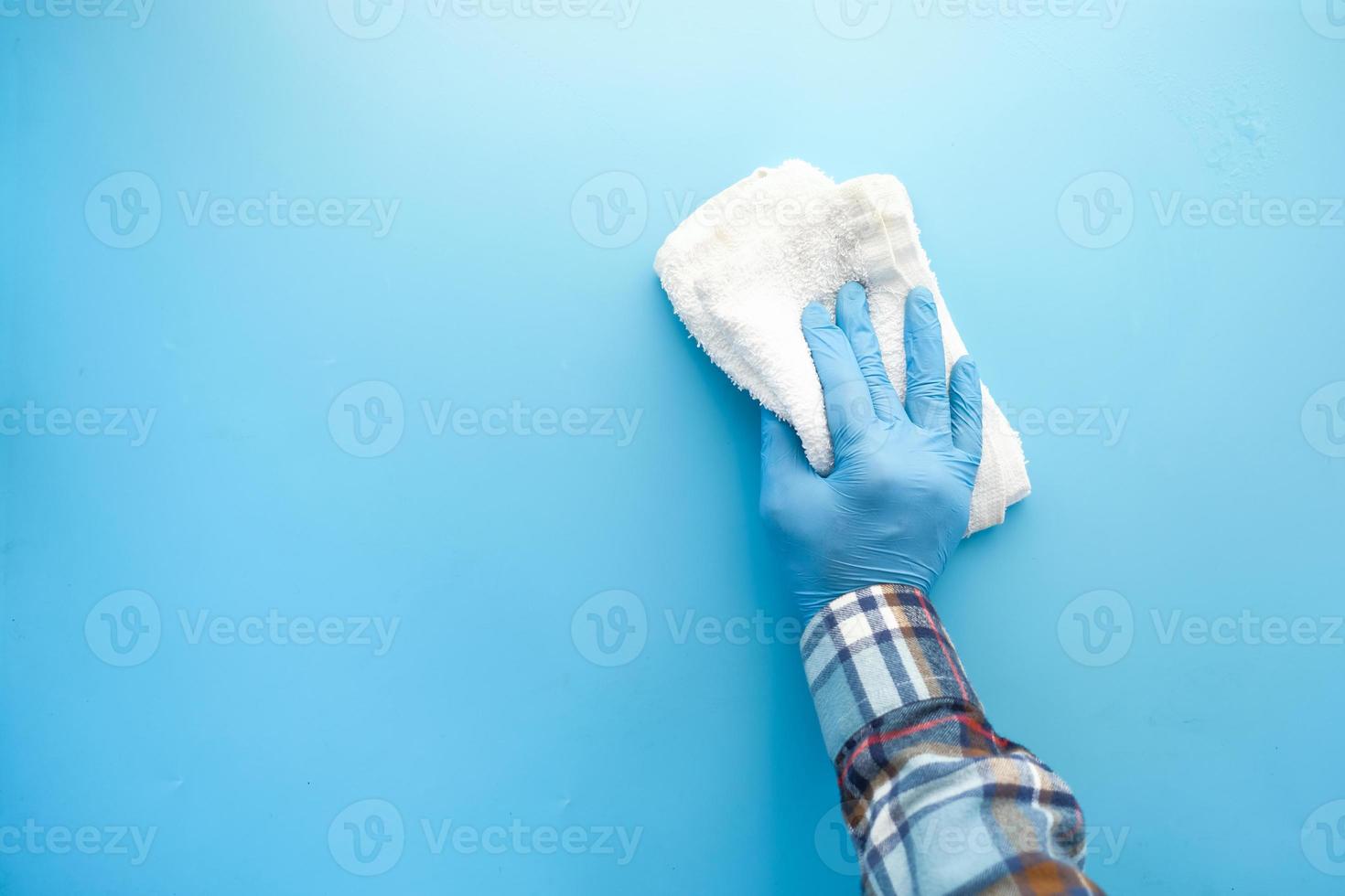 persoon hand in latex handschoenen schoonmaken tafel met doek foto