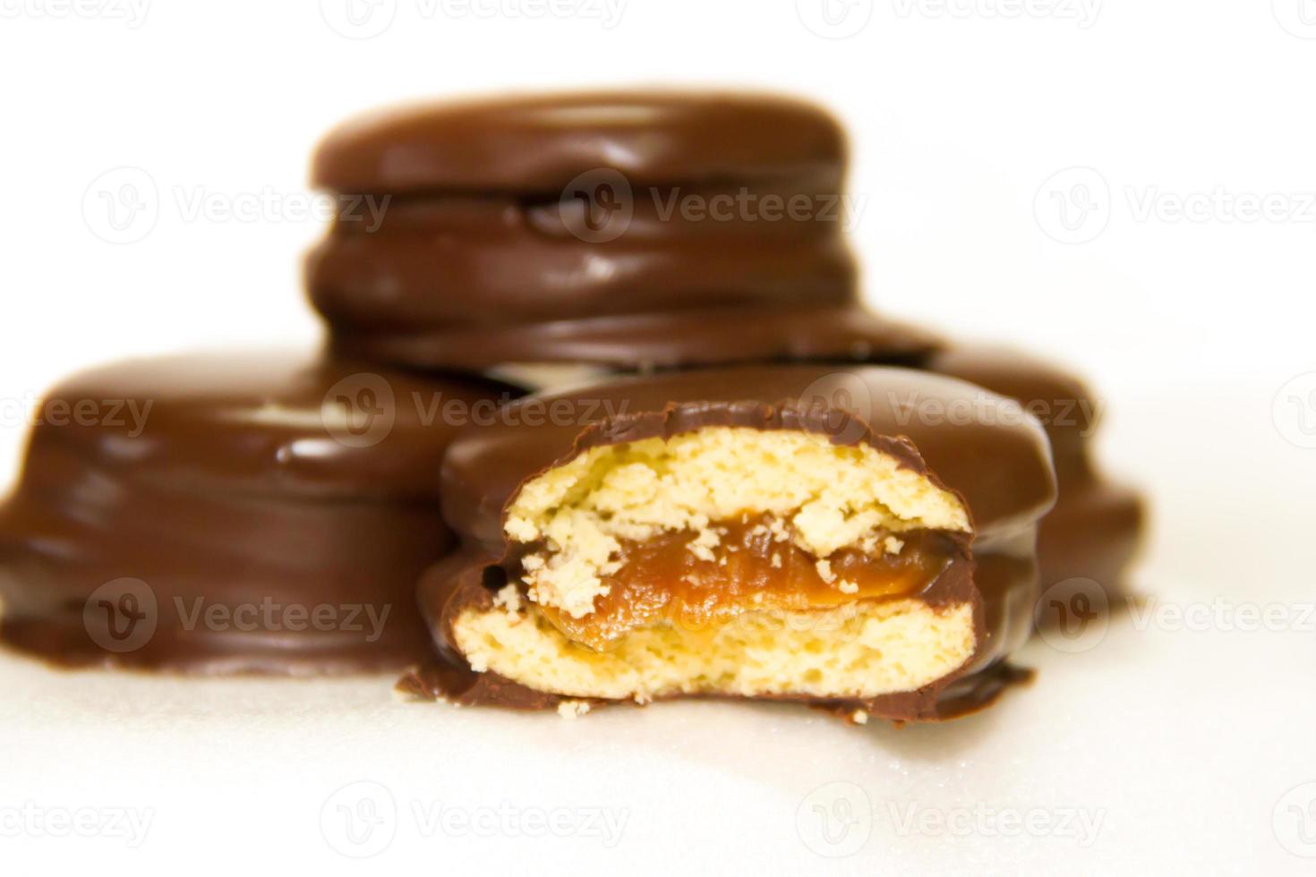 voorbereiding van alfajores van dulce de leche badend in chocola foto