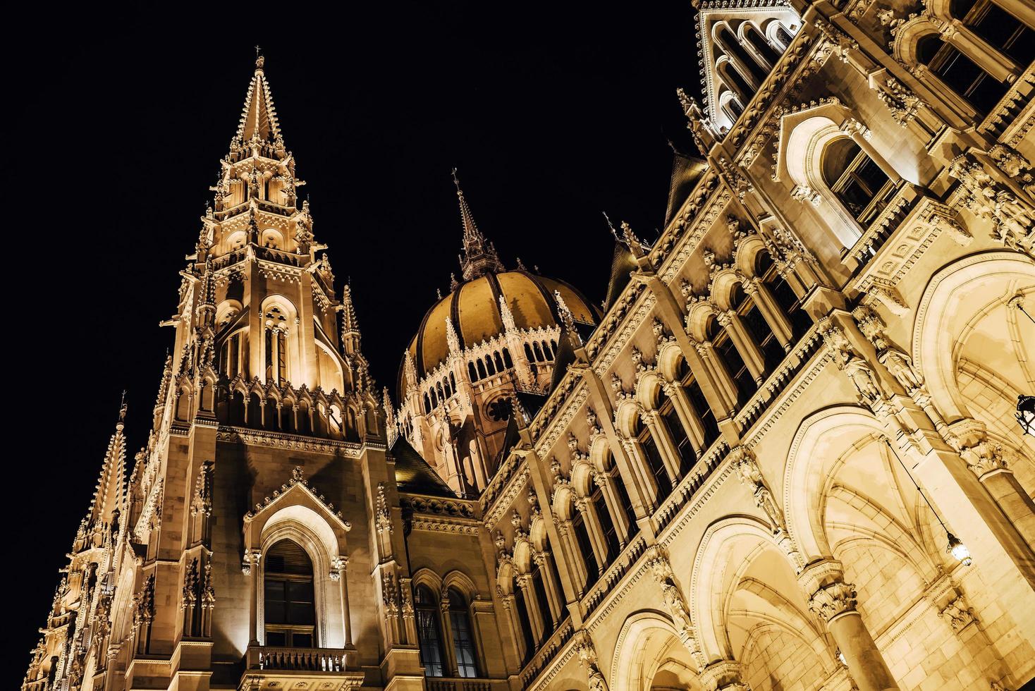 het hongaarse parlement in boedapest aan de donau in de nachtverlichting van de straatlantaarns foto