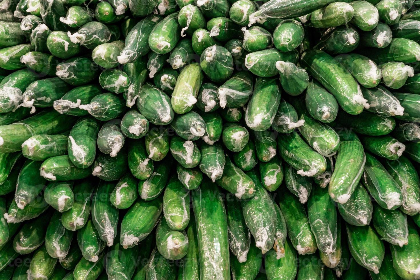 stapel plastic verpakte komkommers foto