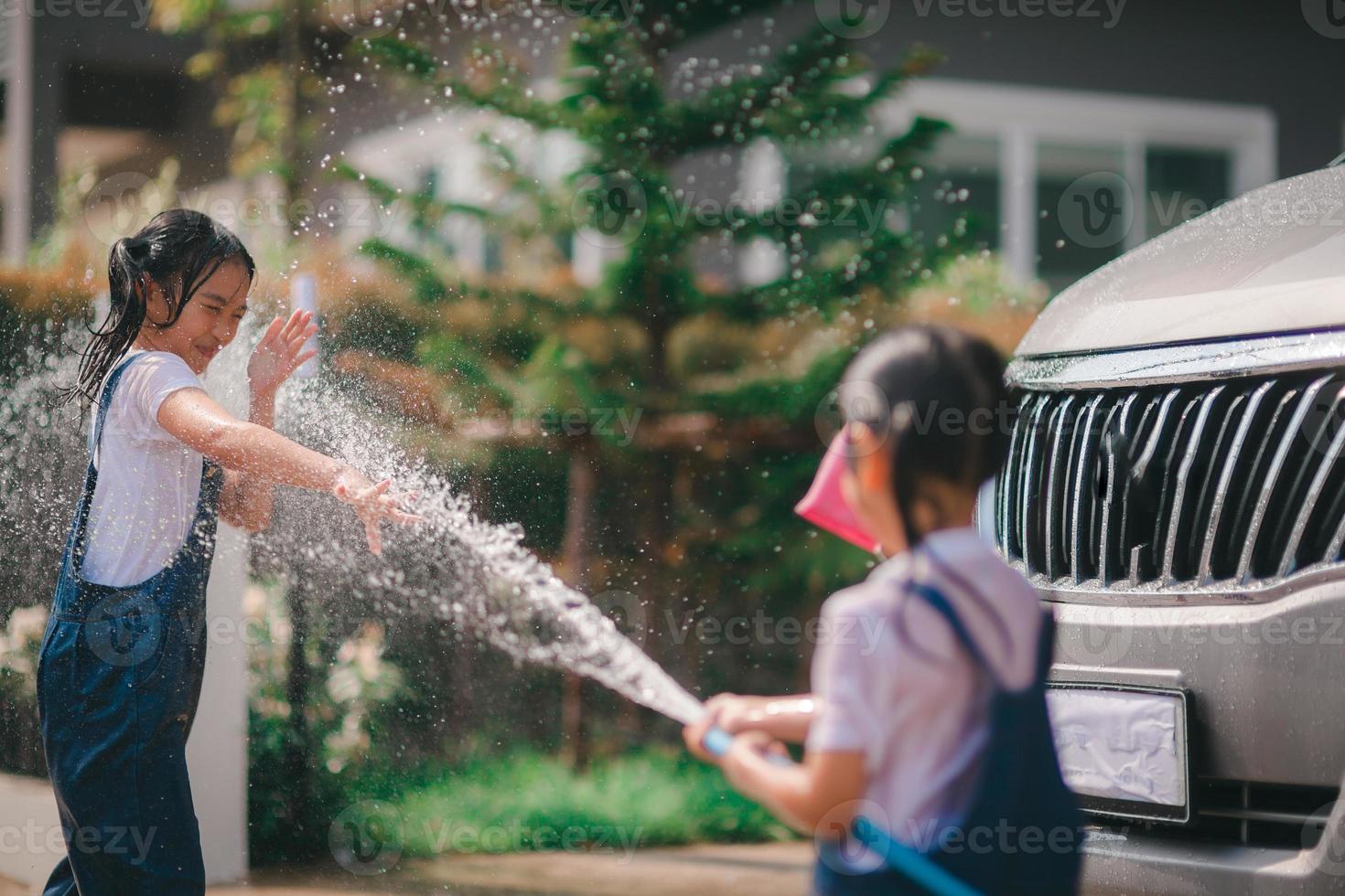 broer of zus Aziatisch meisjes wassen hun auto's en hebben pret spelen binnenshuis Aan een heet zomer dag. foto