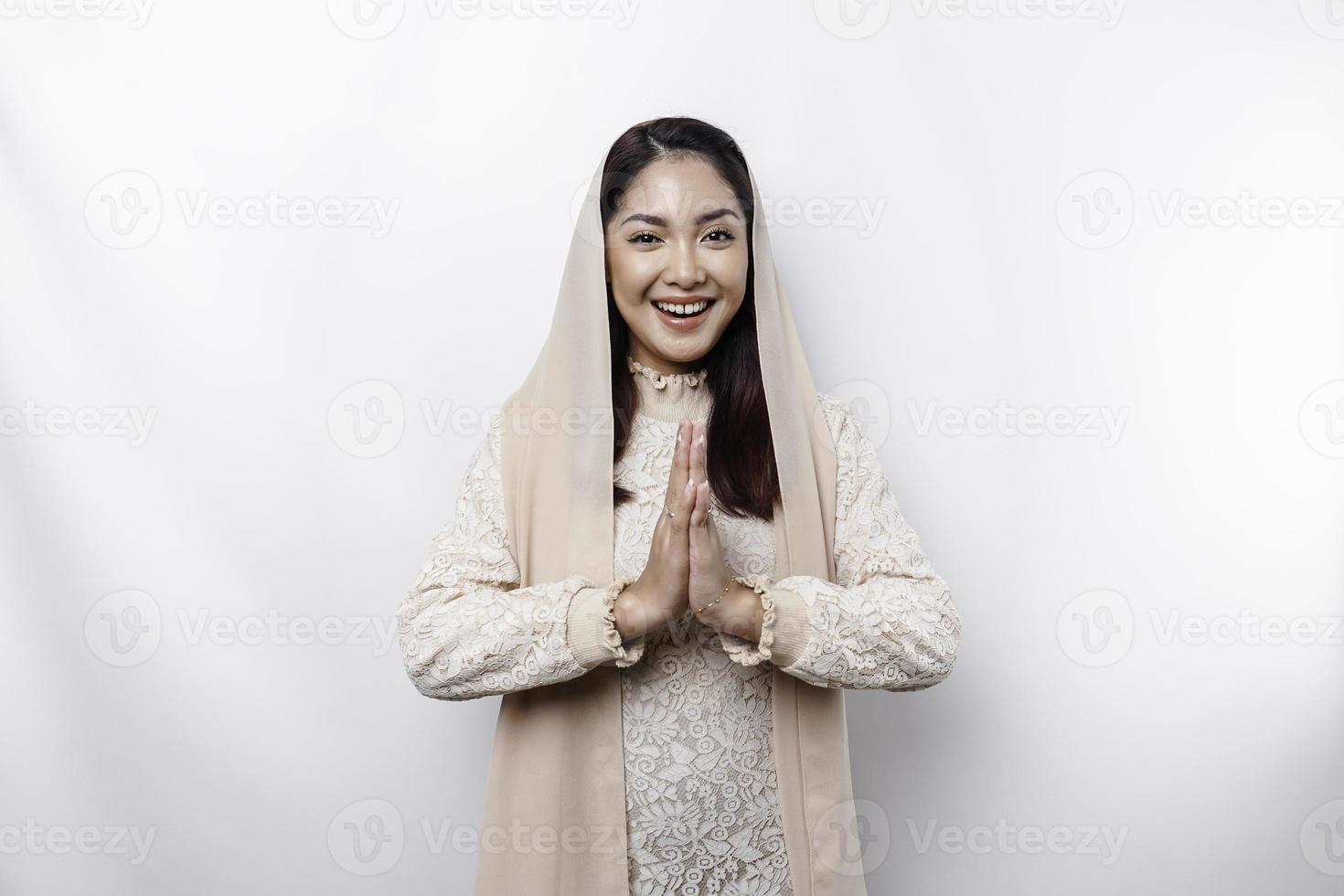 portret van een jong mooi Aziatisch moslim vrouw vervelend een hoofddoek gebaren eid mubarak groet foto