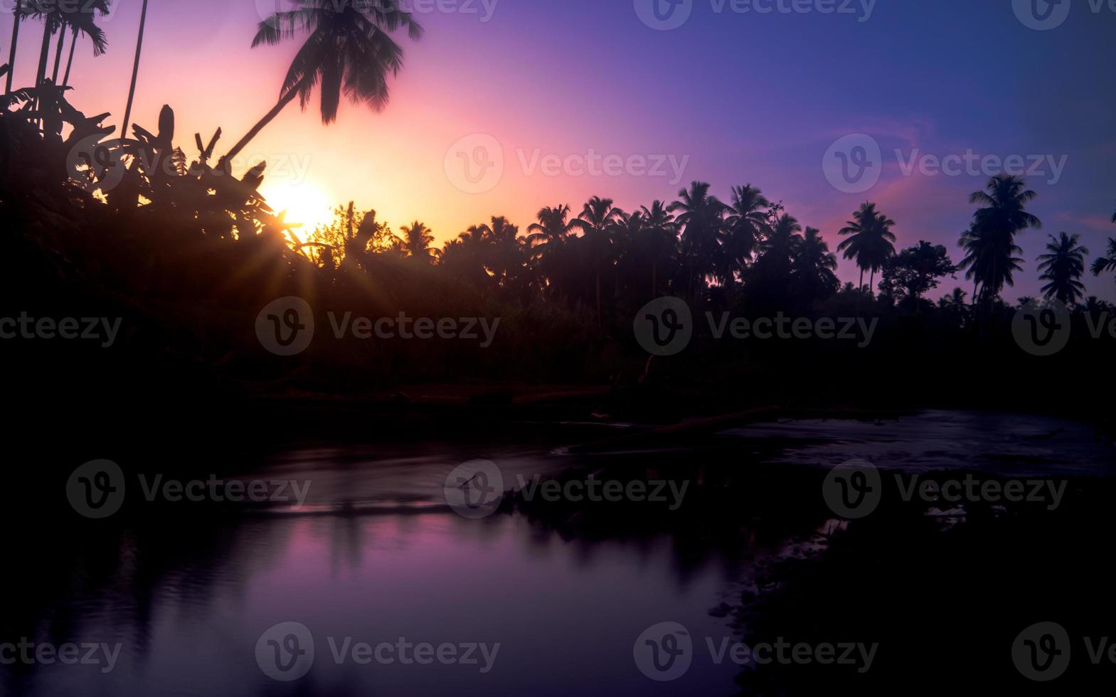 vroeg ochtend- landschap. mooi zonsopkomst met rivier- en bomen in silhouet foto