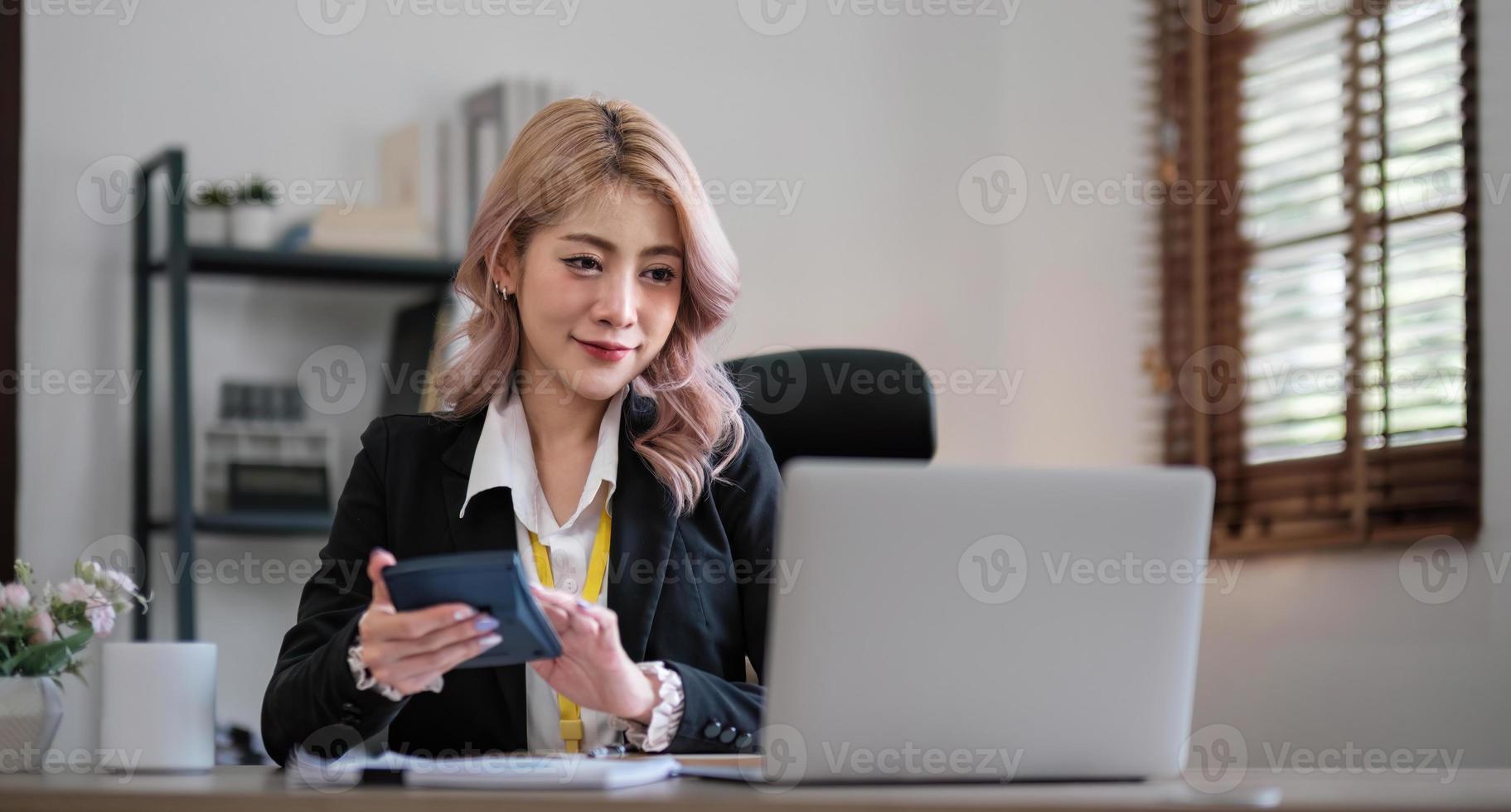 zakenvrouw die rekenmachine gebruikt om wiskunde te financieren op houten bureau in kantoor en zakelijke achtergrond, belasting, boekhouding, statistiek en analytisch onderzoeksconcept foto