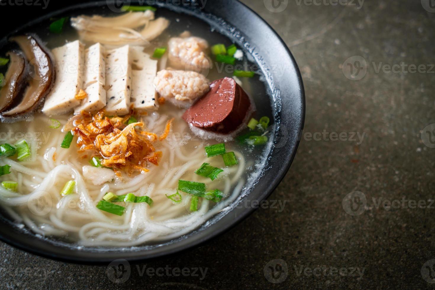 Vietnamese rijstnoedelsoep met Vietnamese worst geserveerd met groenten en krokante ui foto