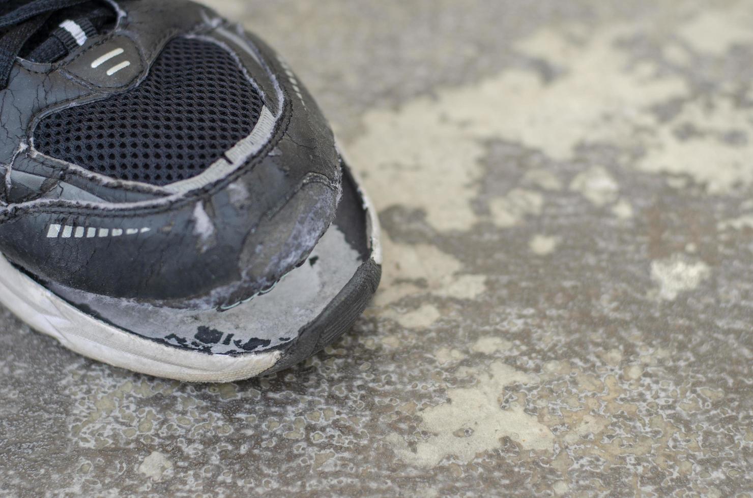 top visie gebroken oud zwart canvas schoenen Aan de vloer. kopiëren ruimte foto