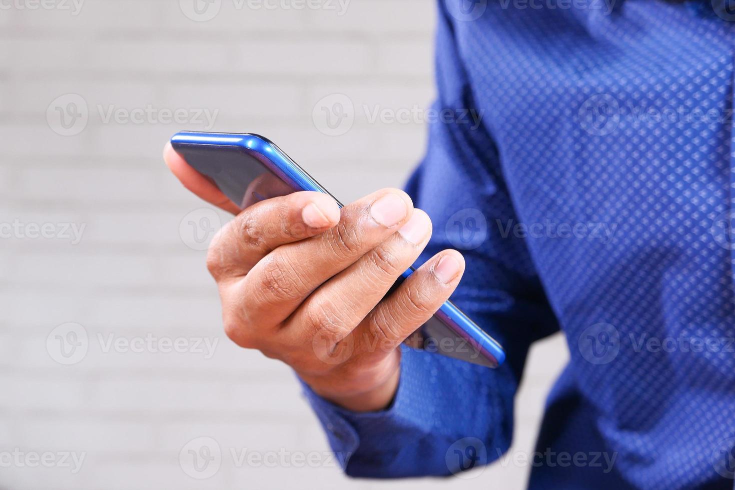 man met een blauwe telefoon op neutrale achtergrond foto